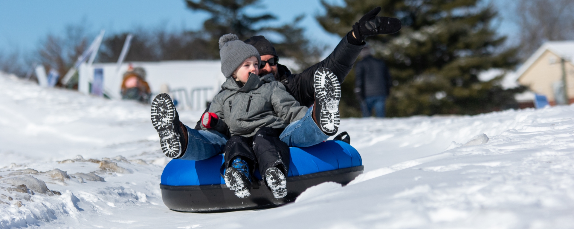 smiling people on a sled, on a snow covered hill